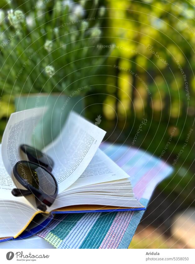 A book with sunglasses lies on a table in the garden, behind it is a white lavender in a pot Garden Book Table Lavender Garden fence plants Sunlight Summer