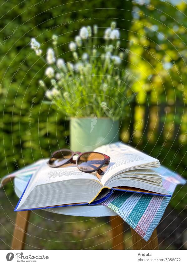A book with sunglasses lies on a table in the garden, behind it is a white lavender in pot No. 2 Garden Book Table Lavender Garden fence plants Sunlight Summer