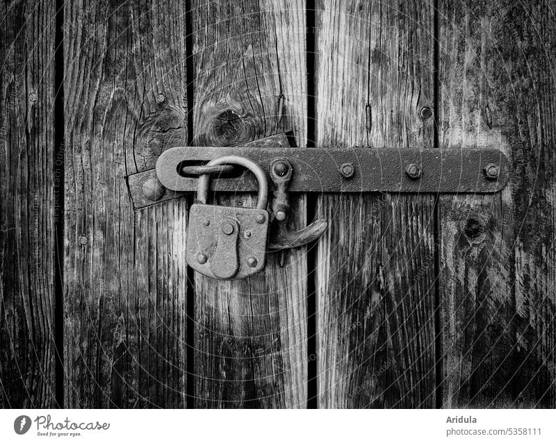 Old padlock locks a barn door made of weathered boards No. 2 Lock Goal Barn Wooden boards Padlock Closed Safety Detail Structures and shapes locked Wooden door