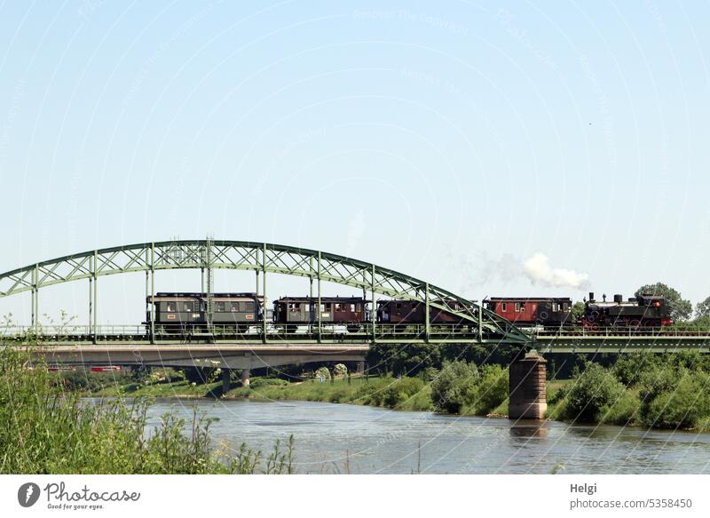 Historic train crosses the Weser river on a railroad bridge Train Railroad Old Bridge Railway bridge River River bank Crossing Track Transport Architecture