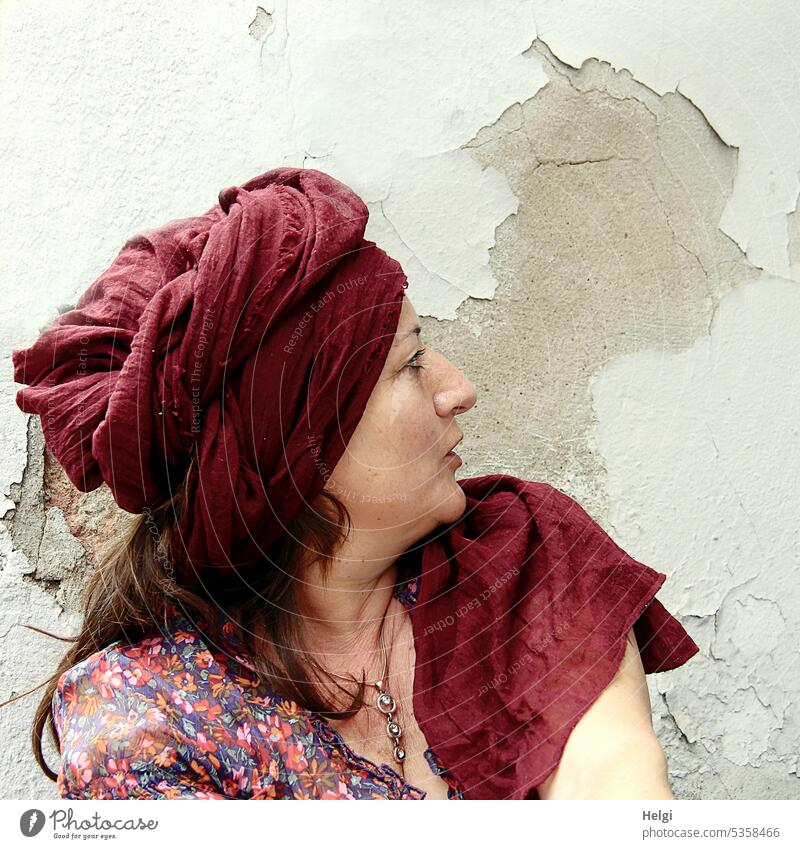 juxtaposition | long haired brunette woman with turban looks to wall on which head is depicted by peeled paint Woman portrait Profile Turban Wall (building)