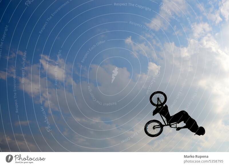 Silhouette of extreme biker bike jump freeride bicycle biking bmx challenge cycling danger fly jumping leap risk silhouette skill sport stunt trick upside-down