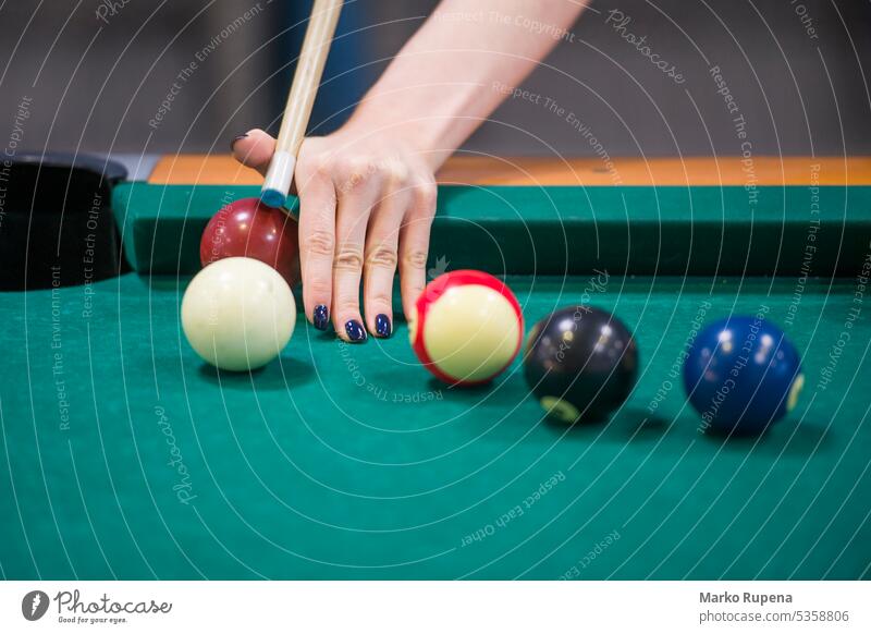 Woman playing billiard game on a pool table hand ball cue chalk green object leisure challenge aiming holding sport equipment competition club stick