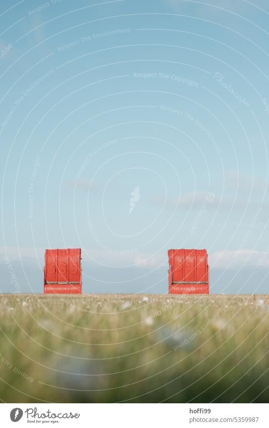 two red beach chairs on a meadow by the sea Red Beach chair Cloudless sky Idyll Loneliness Romance coast Lawn Ocean North Sea Contentment Beautiful weather