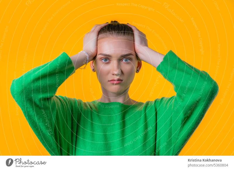 Woman afraid of something, she in shock on yellow backdrop.Holding head adult african background emotion expression eyes face fear frightened gesture girl hair