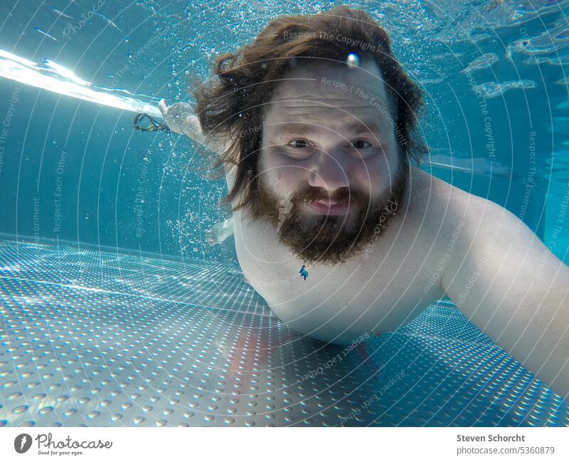 Man diving under water with eyes open in pool or swimming pool Swimming pool Summer vacation Dive be afloat Swimming & Bathing Wet Blue Underwater photo Water
