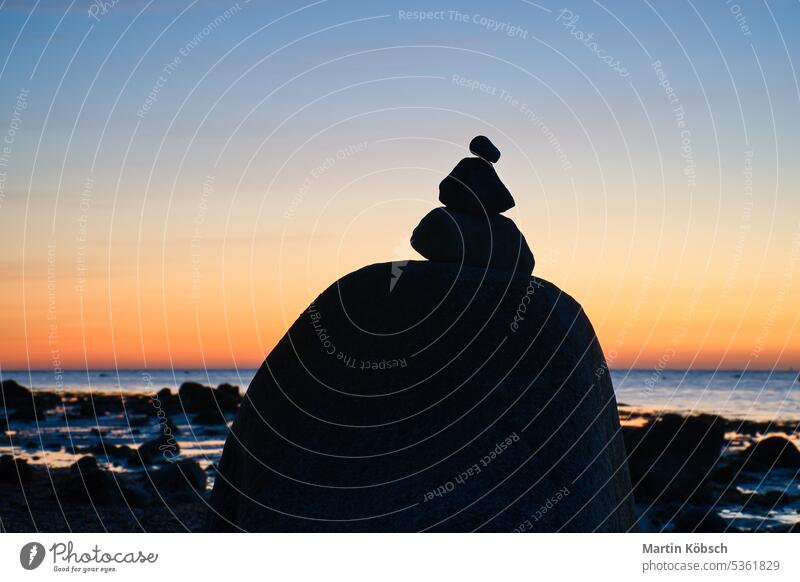 Stone pyramid on the Baltic Sea with a view of the sea at sunset and blue hour stone silhouette ocean pile of stones vacation sky coast art beach relaxation