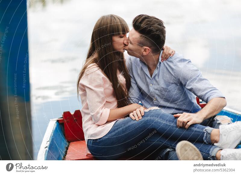 A couple riding a blue boat on a lake. romance. emotional couple. funny and in love young water happy summer river vacation woman ride people beautiful travel