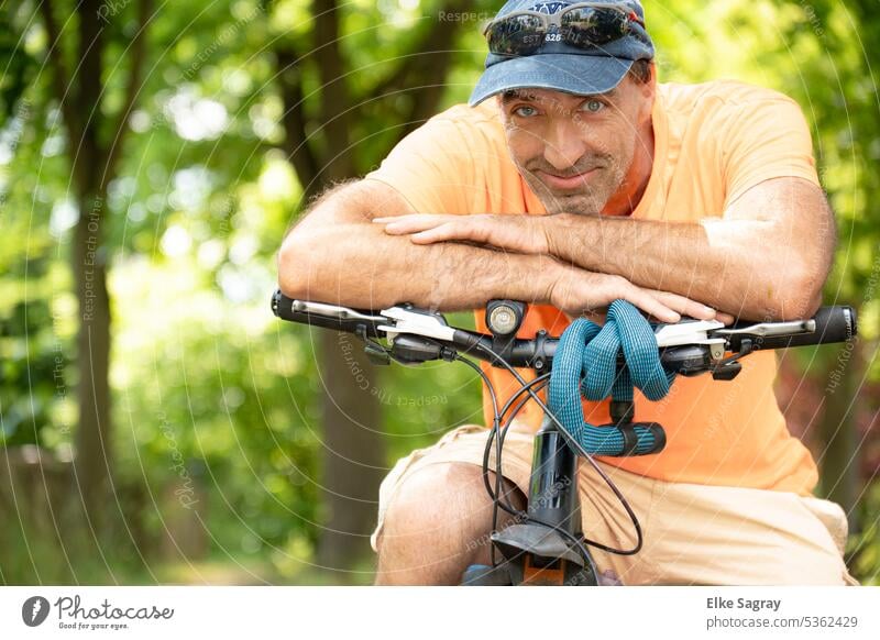 The man with the bicycle looks at the camera Young man Exterior shot Masculine Man Colour photo Face Facial hair Shallow depth of field Looking into the camera