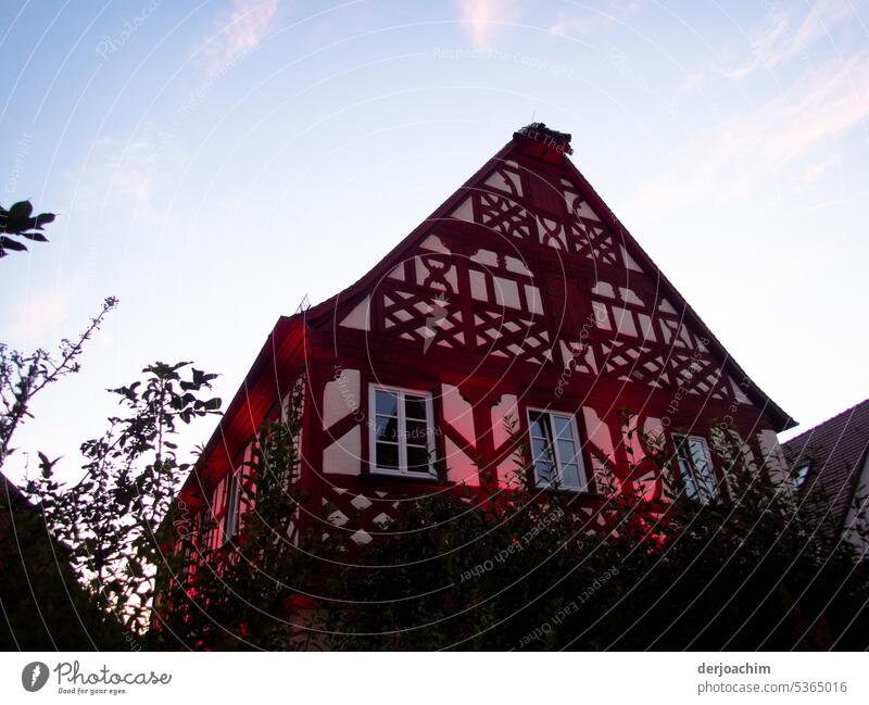 Here is something to celebrate.  Festive illuminated half-timbered house in delicate red. Half-timbered house detail Historic Light Town Exterior shot Old