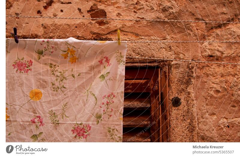 an old fashioned tablecloth hanging on a line to dry, on a brown wall with a window Dry old house wall windows with brown beams clothesline Clothes peg Hang