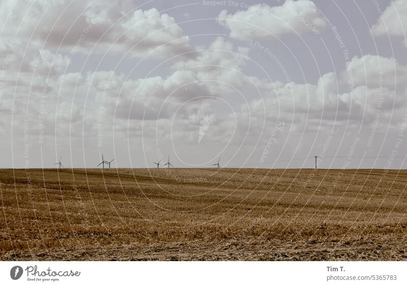 Harvested Field Wind energy plant Sky Colour photo Clouds Summer harvested Agriculture Landscape Nature Energy industry Blue Deserted Exterior shot Grain