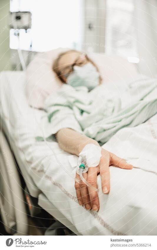 Focus on the woman hand of a patient with medical drip or IV drip in hospital ward , health and medical care concept. medicine illness treatment equipment