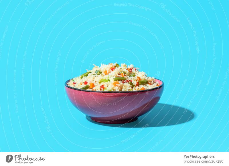 Fried rice with vegetables, an asian dish, on a blue background beans bowl bright carrot chinese close-up color cooking copy space cuisine cut out delicious
