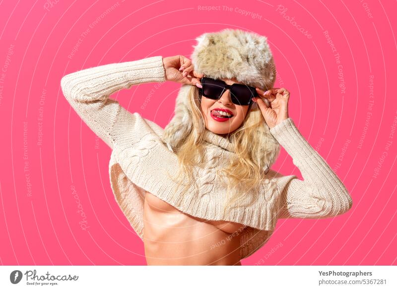 Funny summer concept, a woman with winter clothes and sunglasses attitude background beautiful blonde bright climate color copy space eccentric enjoying