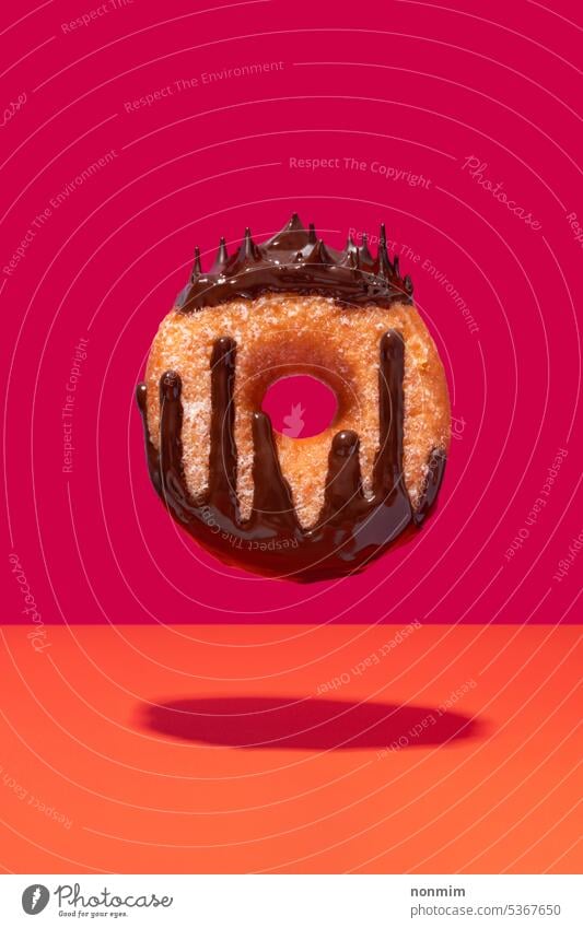 Floating chocolate coated ring doughnut queen concept vibrant pink orange donut crown drop drip melted levitating sweet sugar unhealthy magenta cake circle