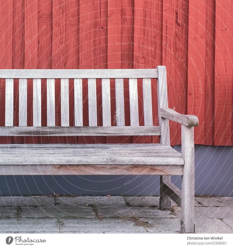 Sunday rest Bench bench Wooden bench Seating Break Relaxation Loneliness Calm Red Blue Facade Weathered Empty seat Wooden facade concrete blocks concrete paving