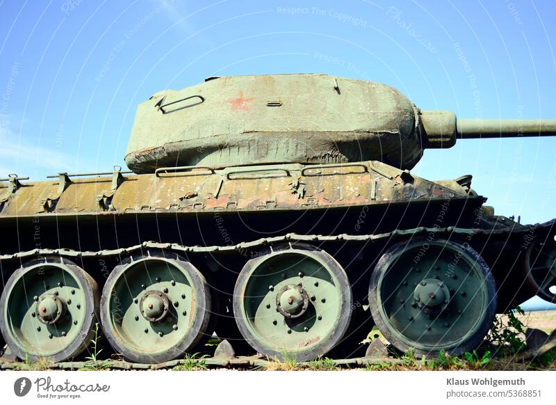 An old T34 of the Russian army waits at the edge of a scrap yard for the things to come Shell Armouring t34 tank chain Roller Stars red star Soviet tank