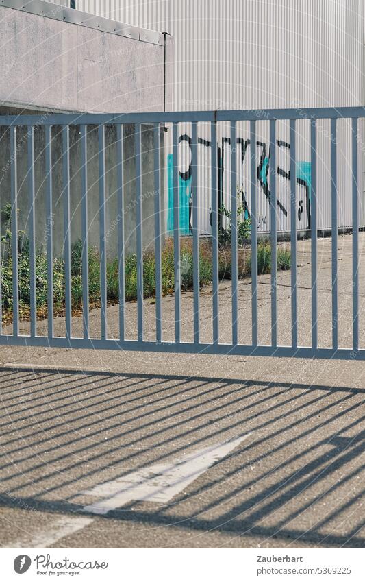 Closed gate, commercial building with graffiti, shadow and arrow symbolizing obstacle, problem or resignation Goal Shadow Graffiti Arrow Gray light gray