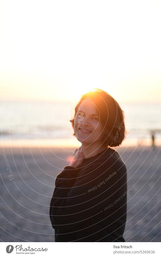 Sunset Woman 30-35 years Brunette Short-haired Sunbeam sunshine Ocean Beach vacation Vacation mood Vacation & Travel Colour photo Adults Exterior shot