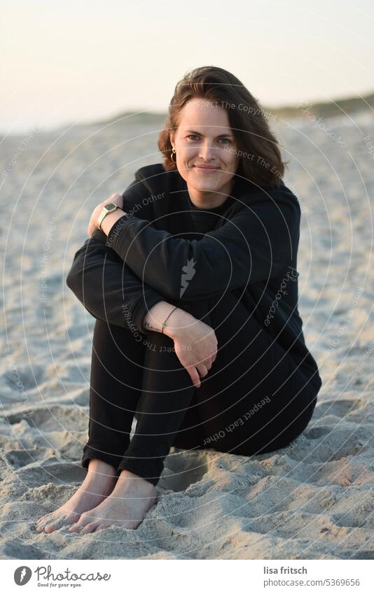 SAND - WOMAN - DUSK Woman 30-35 years Adults Colour photo Sand Beach Cozy black clothes Short-haired Brunette Smiling Contentment naturally Exterior shot