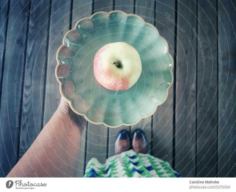 Frau hält einen grünen Teller mit einem Apfel in der Hand Ernährung Vitamine gesund Gesundheit vegan vegetarisch Gemüse Garten gesunde ernährung lecker Natur