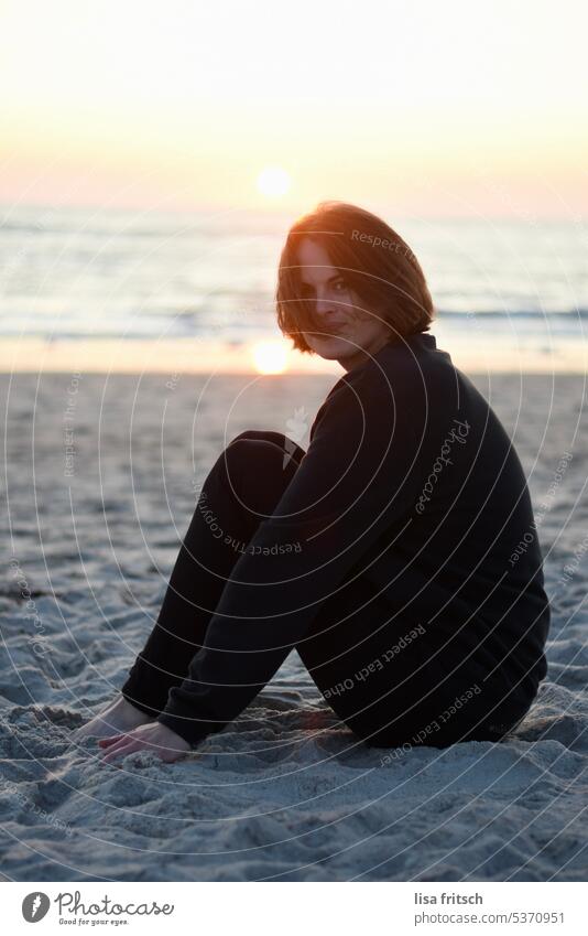 SUNSET AT THE SEA... Woman 30-35 years Brunette Wind in the hair Short-haired Hair on the face sedentary Contentment fortunate Joy Adults Colour photo Feminine