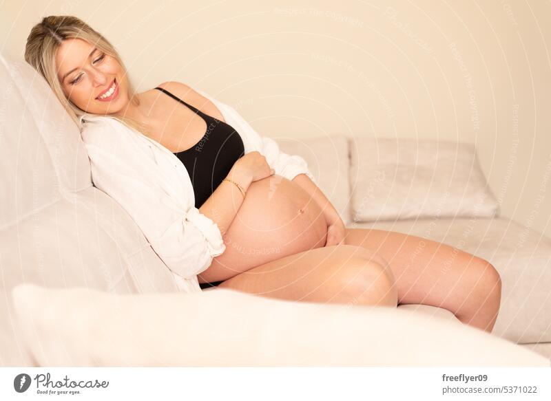 Young pregnant woman in studio lighting portrait young blonde thirties 30s shirt belly mother copy space pregnancy parent parenthood motherhood abdomen female