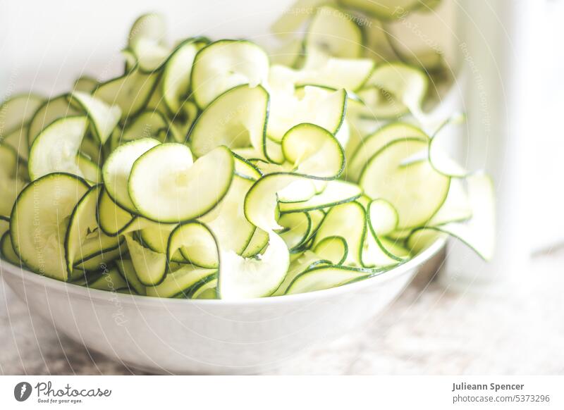 Bowl of sliced shaved zucchini/courgette pasta vegetable pasta white bowl food simple vegan healthy green diet skin on spiralizer edible dinner meal Nutrition