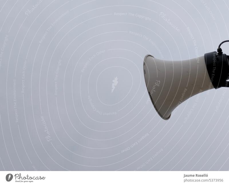 white colored speaker outdoors with sky with gray clouds on one side of the image with copy space. advertisement audio communicate control festival information