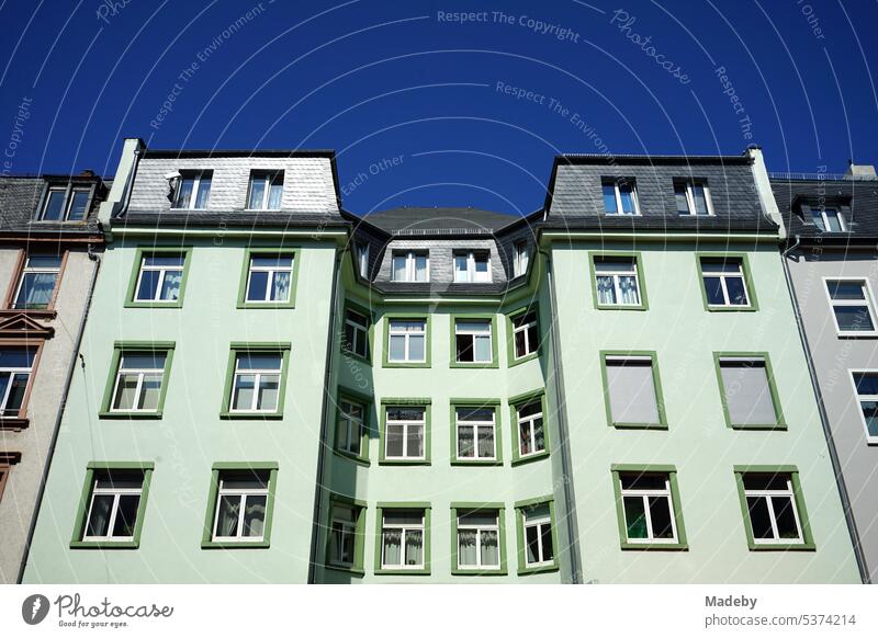 Mint green facade of a renovated old building in summer under blue sky and sunshine in Höhenstraße in the north end of Frankfurt am Main in Hesse, Germany