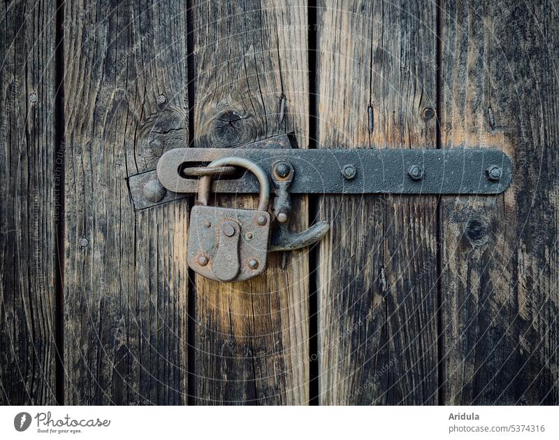 Old padlock locks a barn door from weathered boards No. 3 Padlock Barn Lock Wood Metal Protection Rust Detail Closed Wooden door Safety Structures and shapes