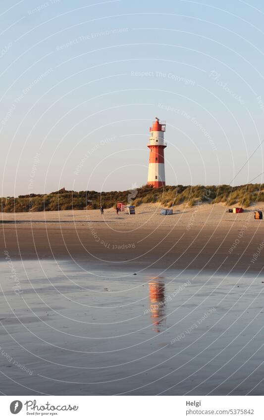 Lighthouse on Borkum beach with reflection in water, dunes and beach tents lighthouse Island Beach Sand Beach tent Sky Beautiful weather Water Summer