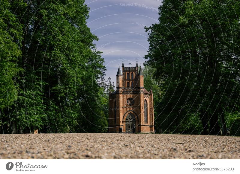 Brick church in the middle of big trees of a park | frog perspective Church Sky Architecture Exterior shot Building Manmade structures Day Colour photo Deserted