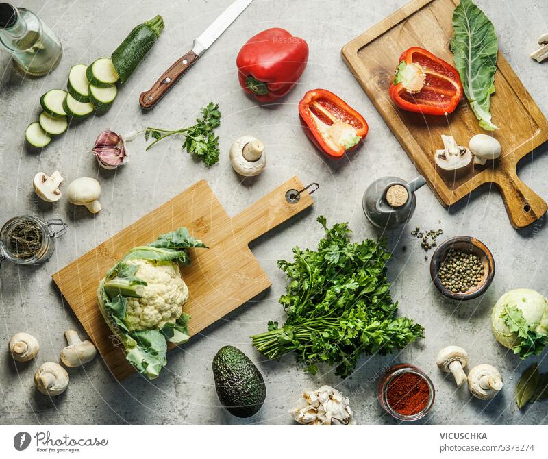 Various healthy vegetables ingredients on kitchen desk background with knife, herbs, spices and cutting boards. Top view. Vegan food various top view vegan food