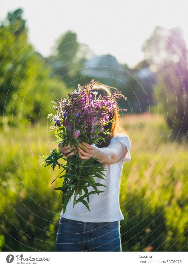 Young woman holds wild flowers bouquet outdoors wildflowers girl faceless summer nature beauty feminine spring colorful vibrant garden meadow stylish fashion