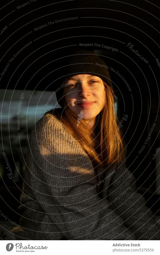 Woman smiling looking at the camera in the sunlight woman enjoy hug sunset carefree delight relax happy jumper rest female evening young bright smile nature