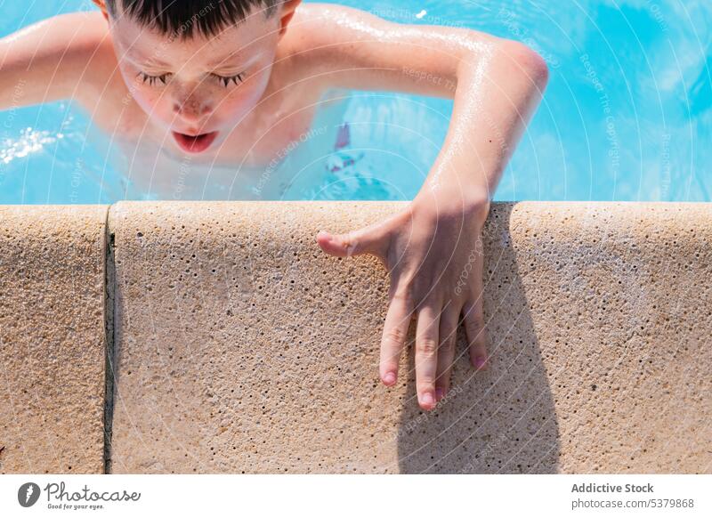 Cute kid in swimming pool and resting hand on poolside water recreation enjoy vacation platform eyes closed preteen child holiday relax summertime edge boy aqua