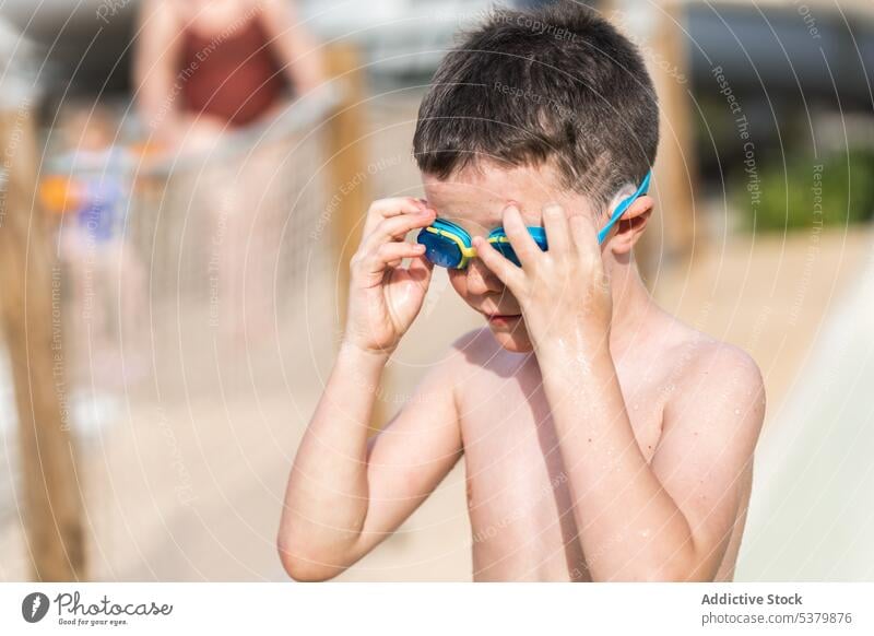 Cute kid standing in sunlight with water goggles child park shirtless adorable adjust recreation summer nature childhood boy weekend vacation swimmer cute