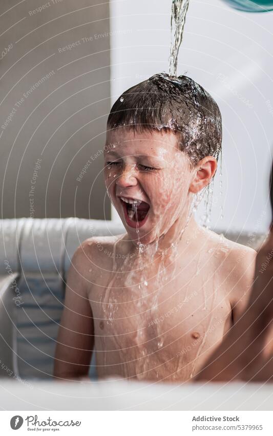 Excited kid screaming in children pool with eyes closed boy water mouth opened having fun happy play wet hair shout yell bathtub excited playful enjoy cheerful