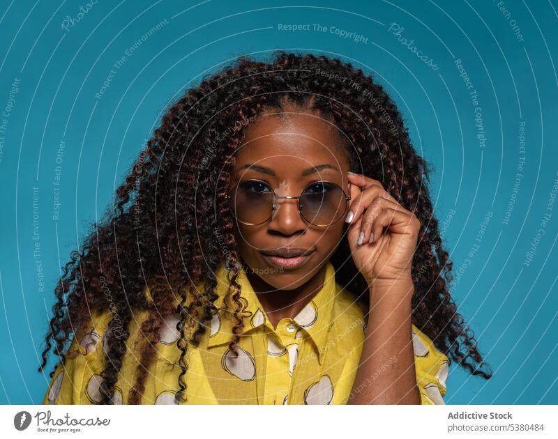 Serious stylish woman in trendy outfit with eyeglasses portrait positive fashion hairstyle model female black african american young curly hair appearance lady