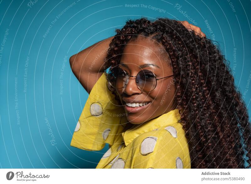 Elegant smiling woman with curly hair looking at the camera laugh happy cheerful humor fun enjoy glad smile female black african american eyeglasses young