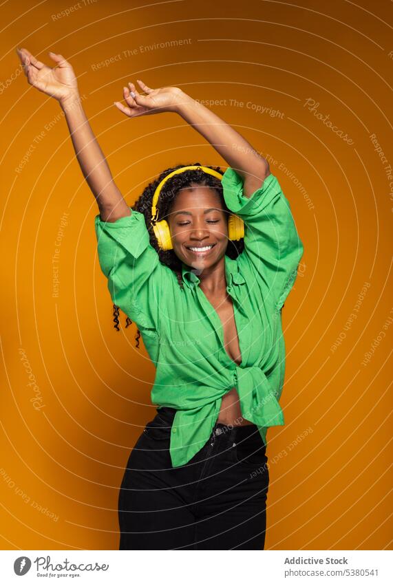 Woman in headphones listening to music and dancing woman earphones dance song relax smile cheerful female black african american headset playlist melody rest