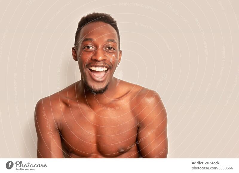 Cheerful black man with naked torso looking at camera smile happy shirtless portrait model personality cheerful positive african american male ethnic young