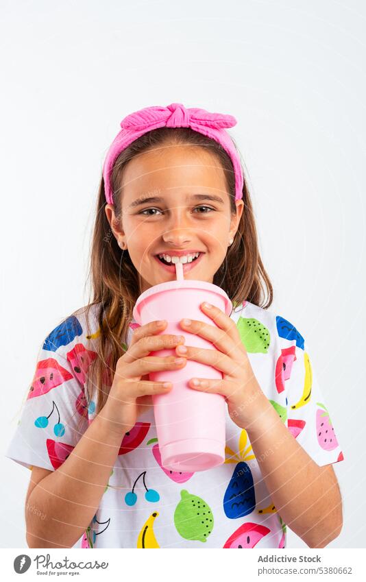 Girl with plastic cup of milkshake girl smile positive happy drink little childhood glad headband kid optimist content studio shot healthy refreshment pure