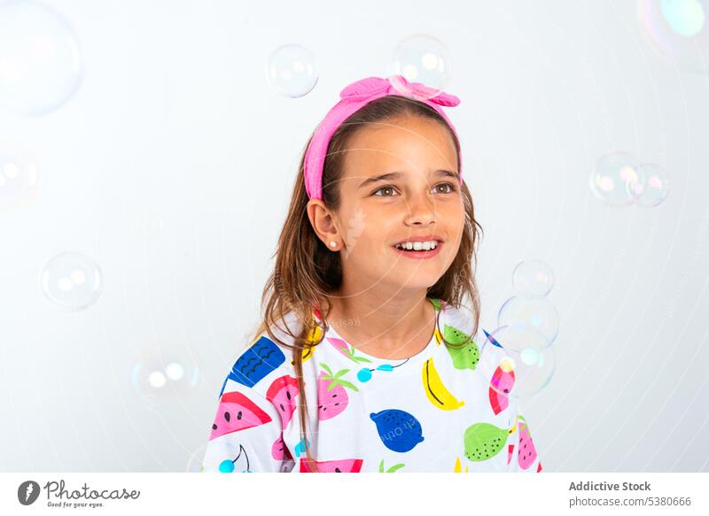 Happy girl in colorful outfit with bubbles soap bubble child kid happy smile positive glad childhood little headband optimist enjoy having fun preschool