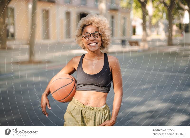 Cheerful black sportswoman with basketball on street player game athlete park young african american female court content lifestyle smile training activity