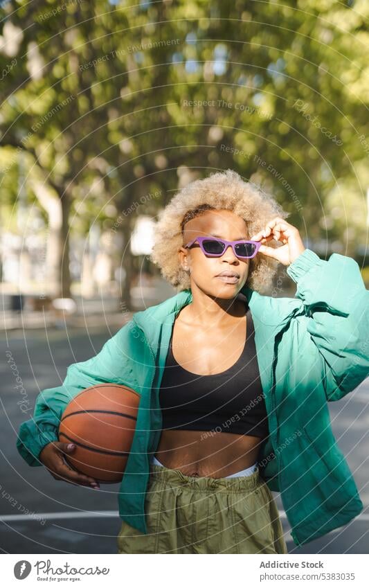 Serious woman in stylish sunglasses with basketball on street portrait style trendy confident city summer modern young female urban outfit appearance ethnic