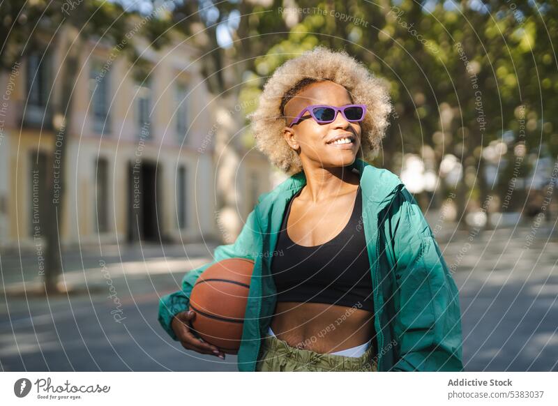 Smiling woman in stylish sunglasses with basketball on street portrait smile style trendy happy positive confident city cheerful glad summer modern young female