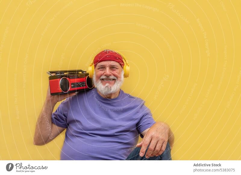 Cheerful man with retro cassette player and headphones smile happy excited music portrait cheerful melody senior elderly male aged old tape audio listen